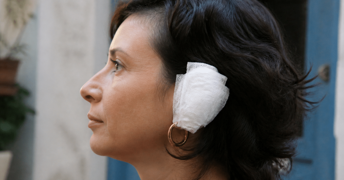 Bandage blanc couvrant completement une oreille avec boucle visible dessous