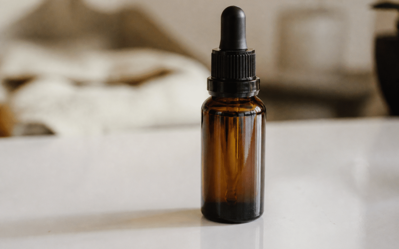 Bouteille de liquide CBD posee sur surface blanche brillante
