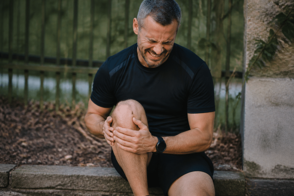 Personne tenant sa jambe gonfl?e avec expression de douleur intense