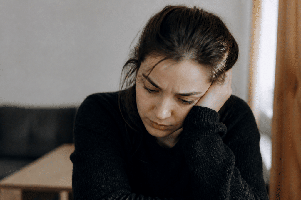 Personne frustrée regardant vers le bas, expression de tristesse et irritabilité visibles