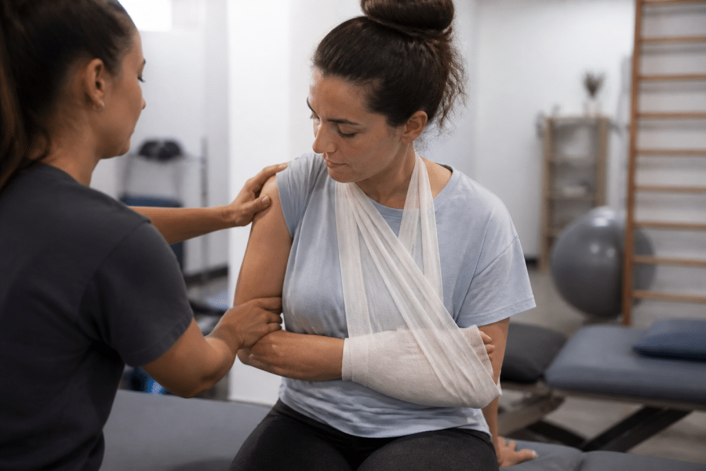 Patient en rééducation avec physiothérapeute, épaule bandée