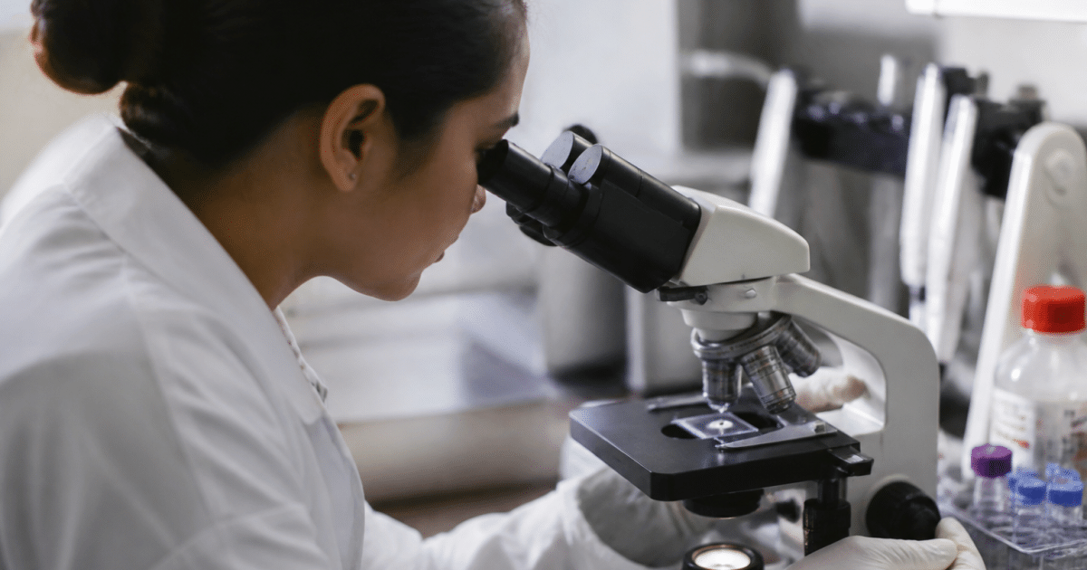 Technicien analyse echantillon sanguin sous microscope laboratoire