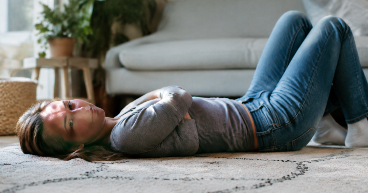 Femme allongee sur tapis bras croises genoux plies