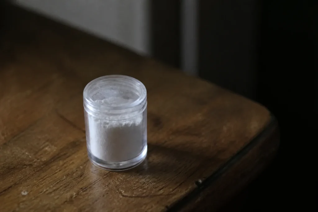Flacon de poudre blanche sur une table en bois