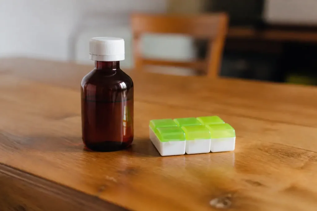 Flacon de sirop et pilulier sur table