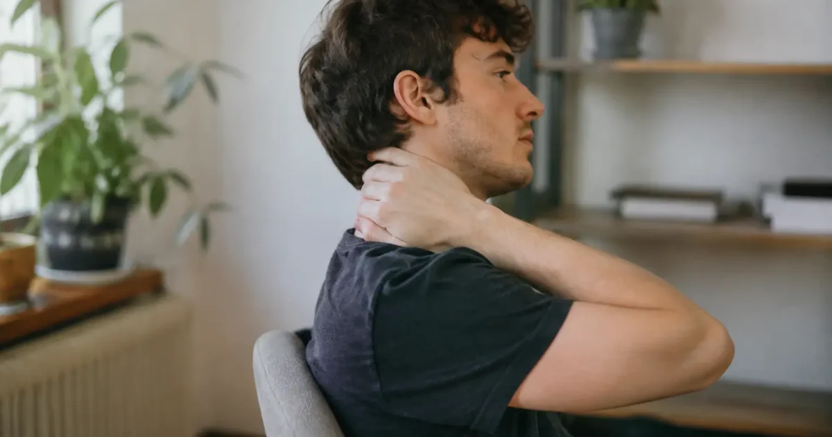 Homme assis de profil massant sa nuque
