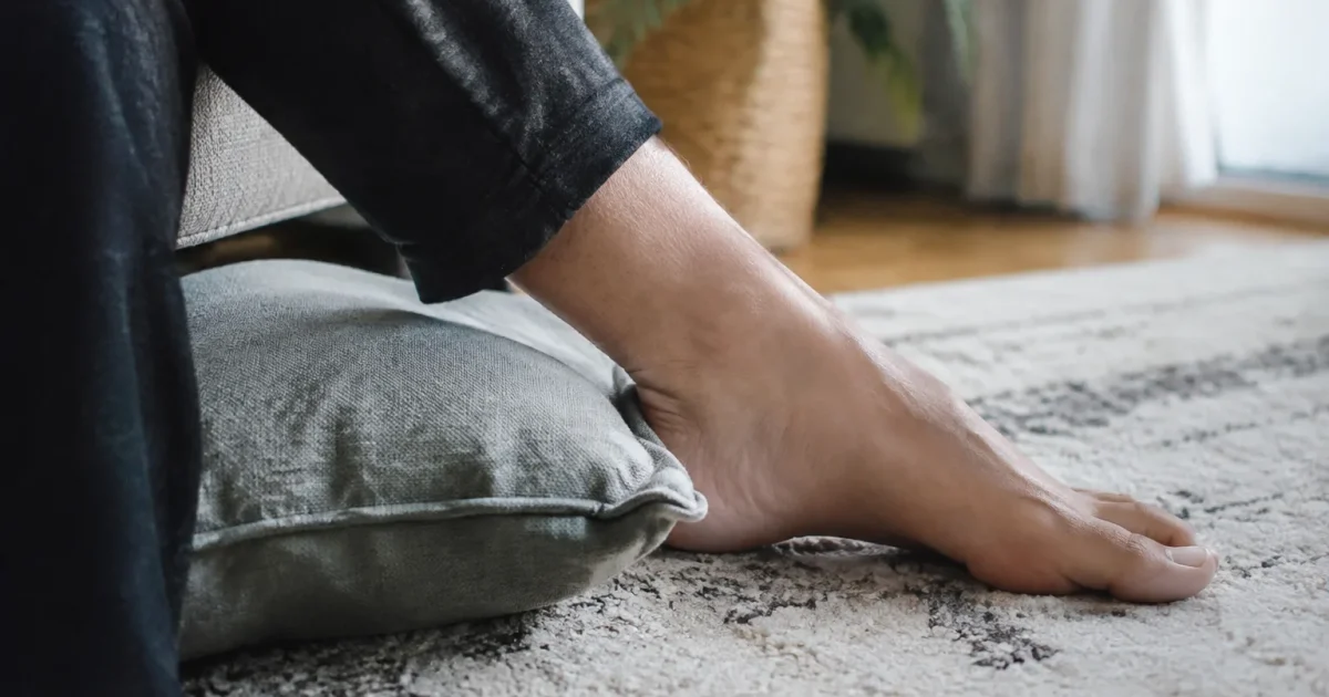 Pied nu pose sur tapis, talon cale par coussin
