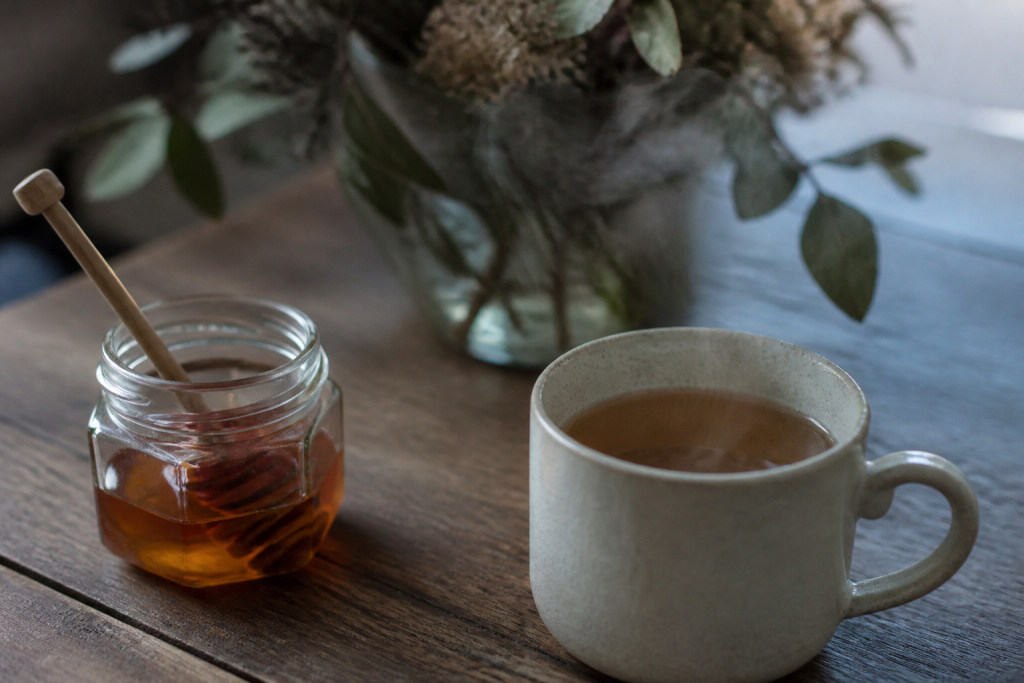 Tasse de the fumant et miel sur table